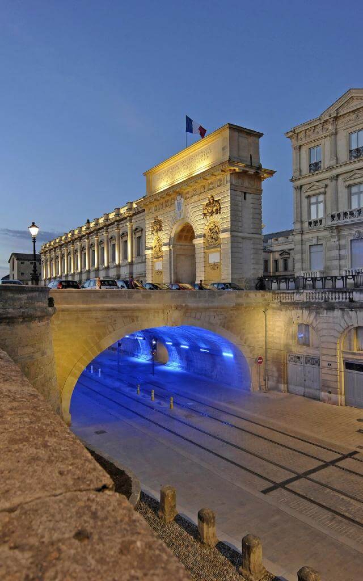 Arc de Triomphe du Peyrou à Montpellier illuminé au crépuscule avec bassin d'eau